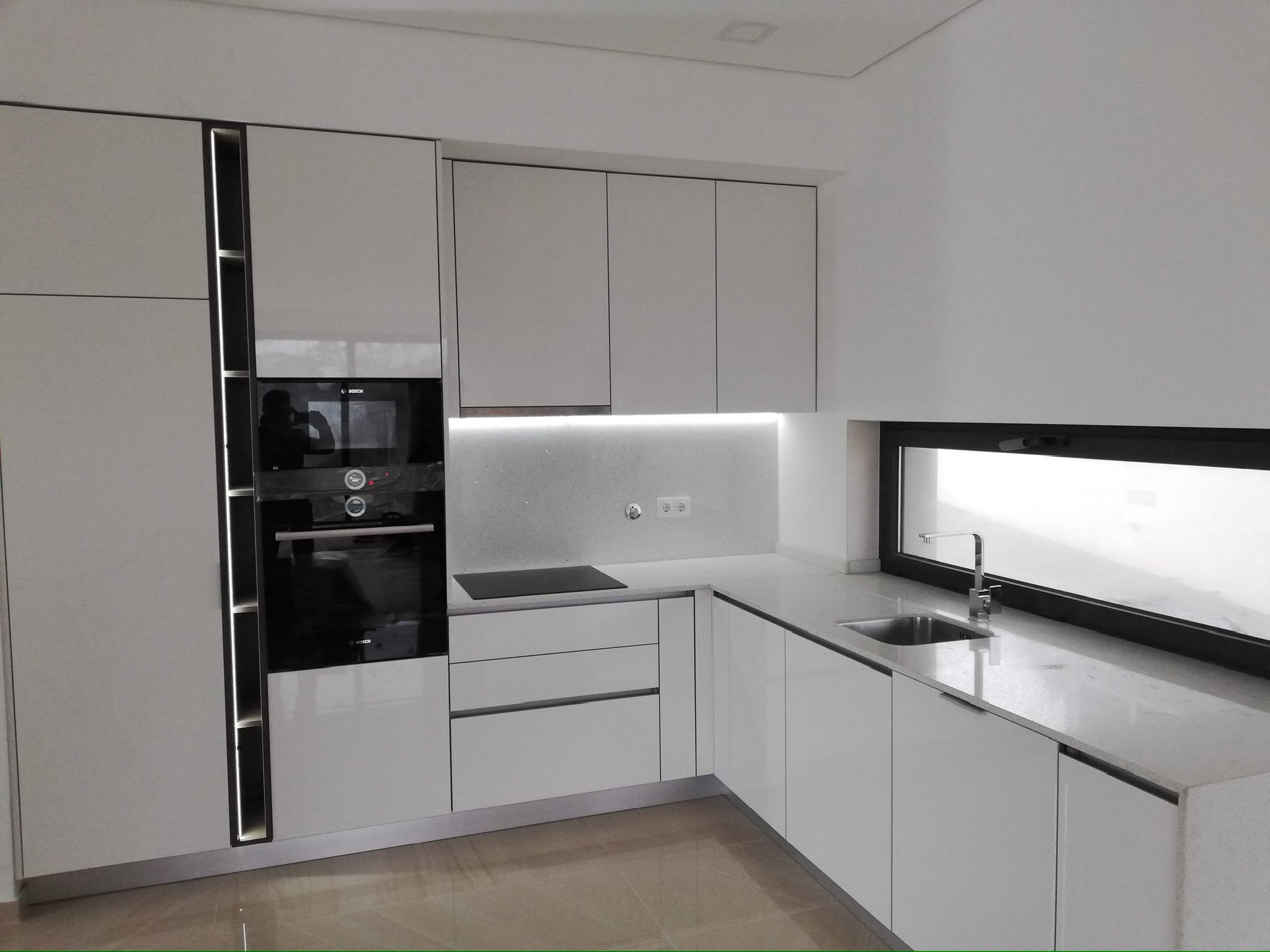 Cozinha moderna lacada com ilha central e iluminação encastrada