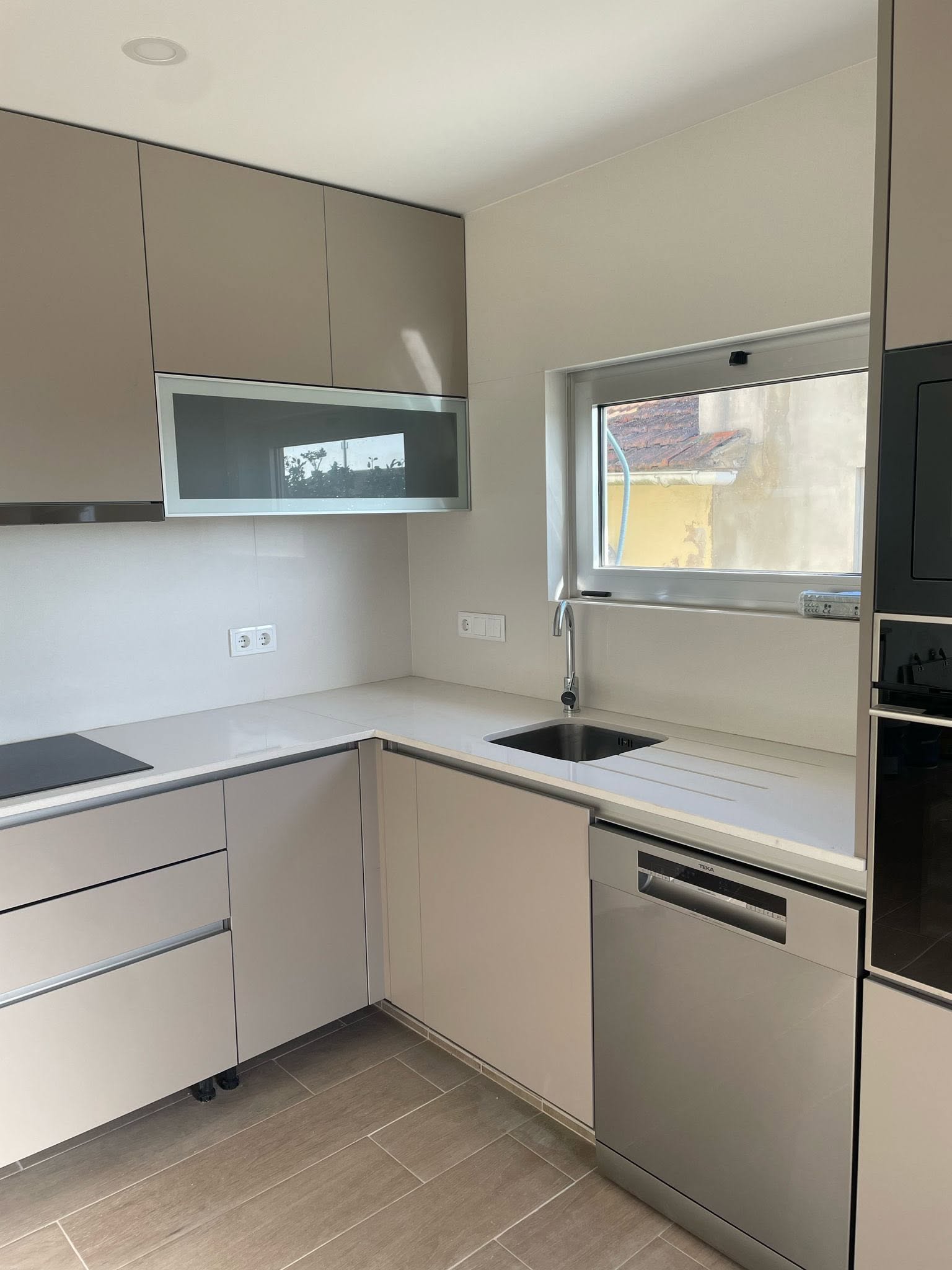 Cozinha em L com frente em madeira e bancada em mármore