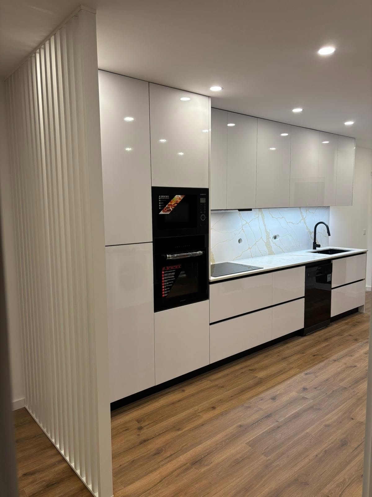 Cozinha em madeira e branco com fornos integrados