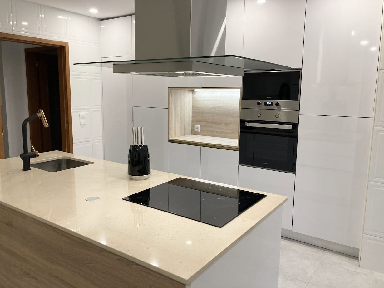 Cozinha com ilha em madeira, placa de indução preta e bancada bege